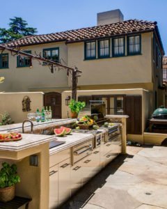 A Spanish style home in Palo Alto has an outdoor kitchen with a grill.